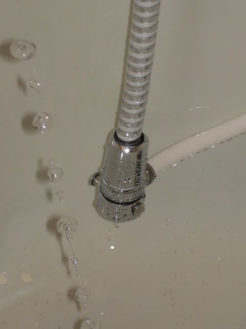 Cool that the lens slowed the water down so much!  This is the filter's aerator, that would normally attach to the sink, so here, it's attached to where the shower massage used to be, and it leaks a tiny bit, but that's not an issue since it's right over the tub drain!